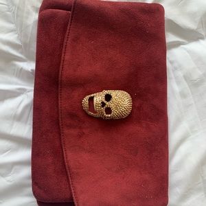 Maroon suede clutch with gold skull